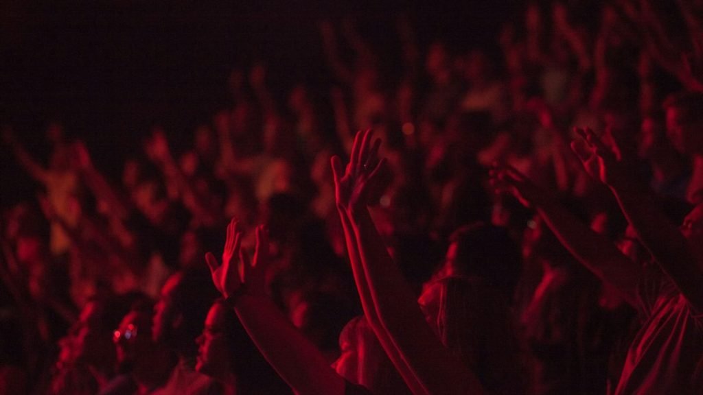 Concert crowd raising hands at show