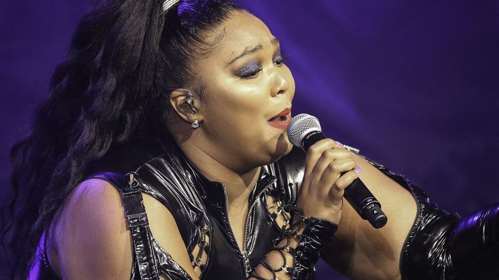 Lizzo performs with mic