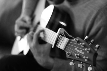 Person strumming ghost-themed electric guitar