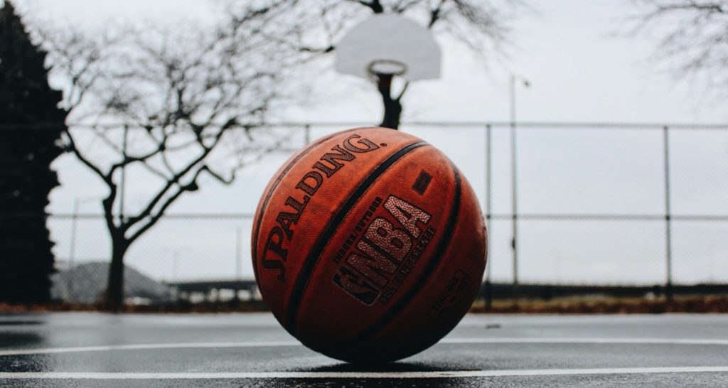 Wet basketball on glossy court surface