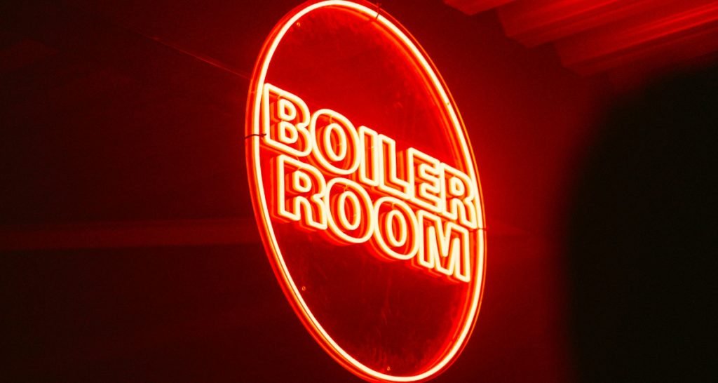 Neon Boiler Room sign glowing red